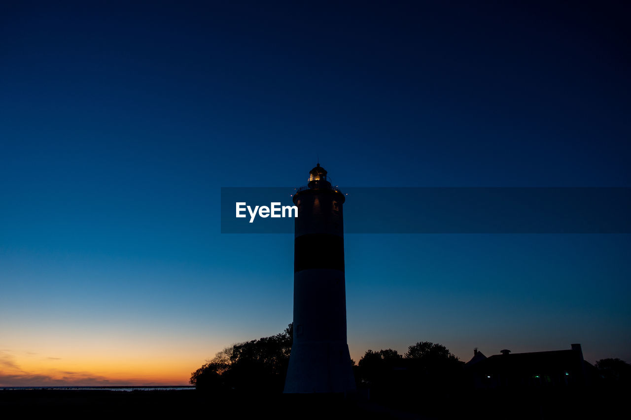 Low angle view of lighthouse against sky at sunset