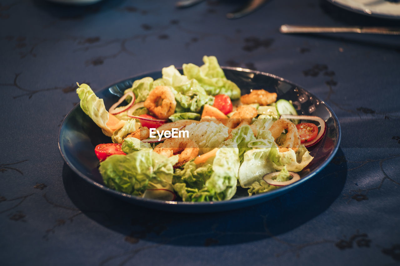 Shrimp salad in a black plate