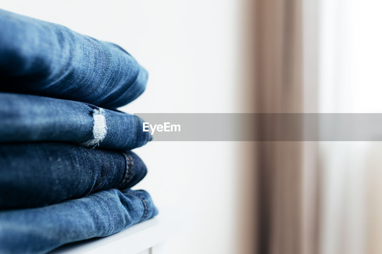 A stack of blue denim jeans or pants. textile industry concept. clothing store concept. sale concept