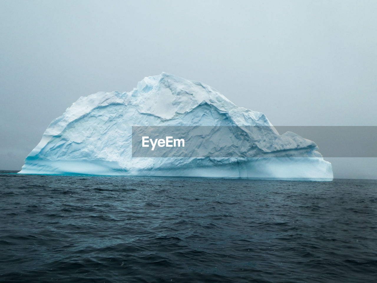 Large blue iceberg on dark water in antarctica