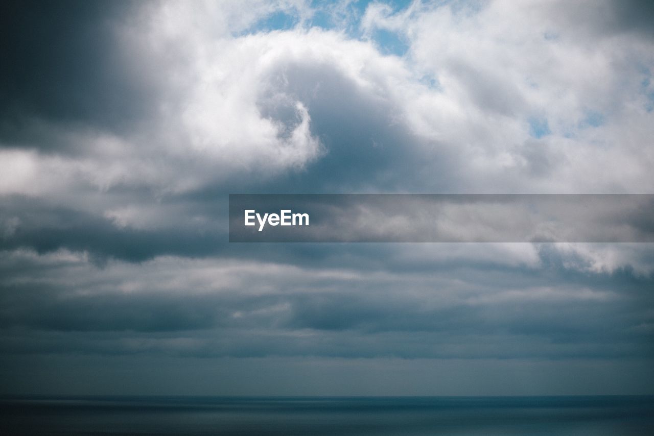 Scenic view of sea against storm clouds
