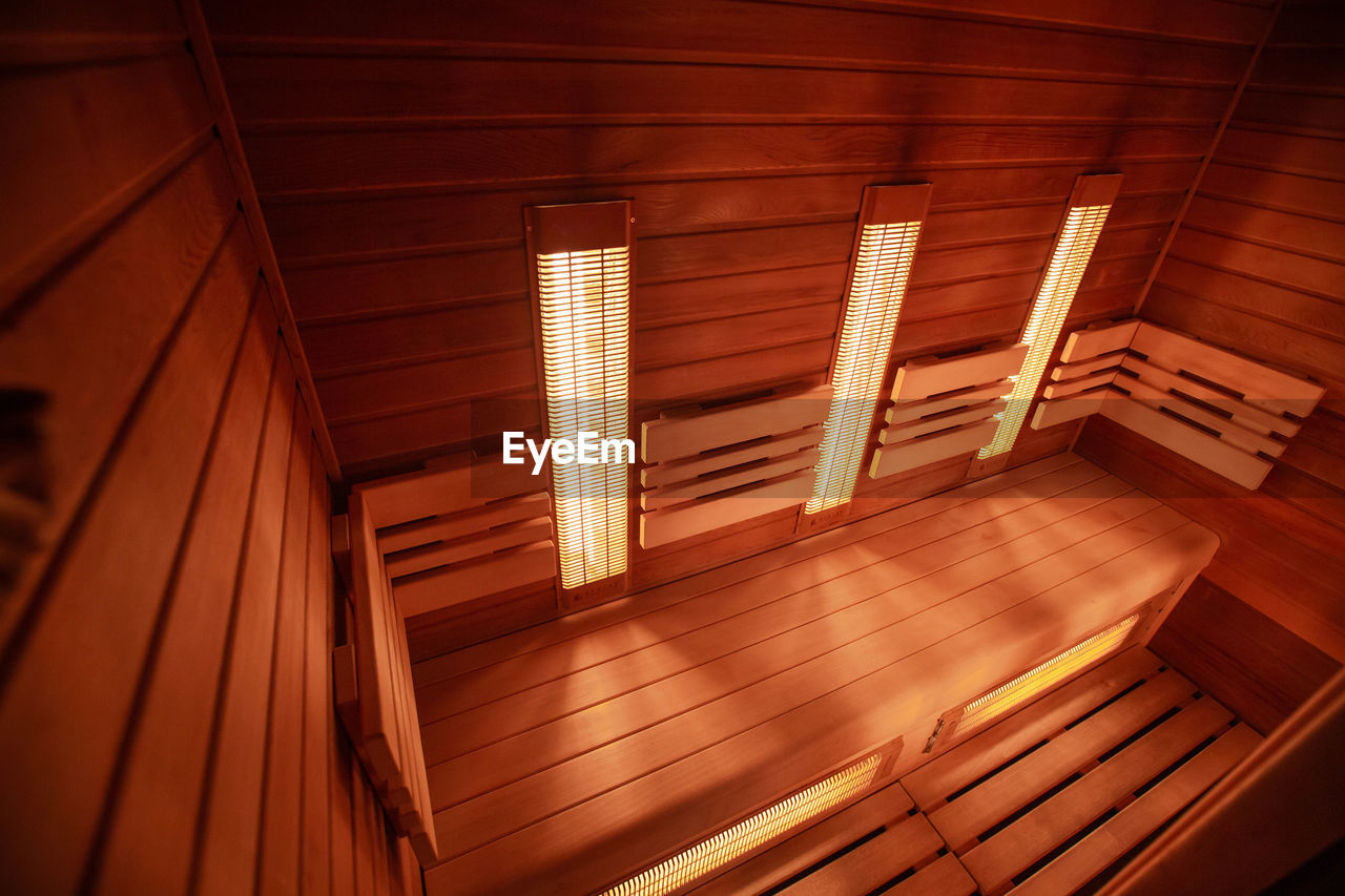 LOW ANGLE VIEW OF ILLUMINATED LIGHTS ON CEILING OF BUILDING