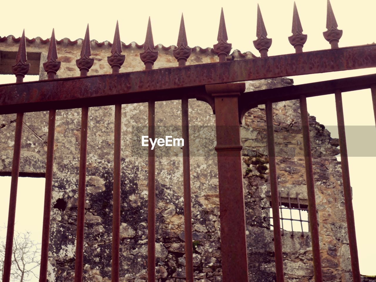 Rusty fence against abandoned building