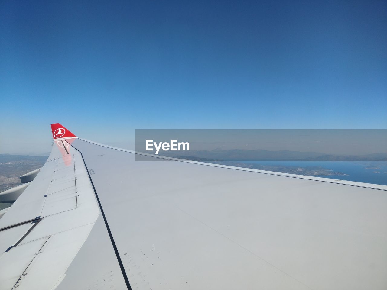 CLOSE-UP OF AIRPLANE WING AGAINST SKY