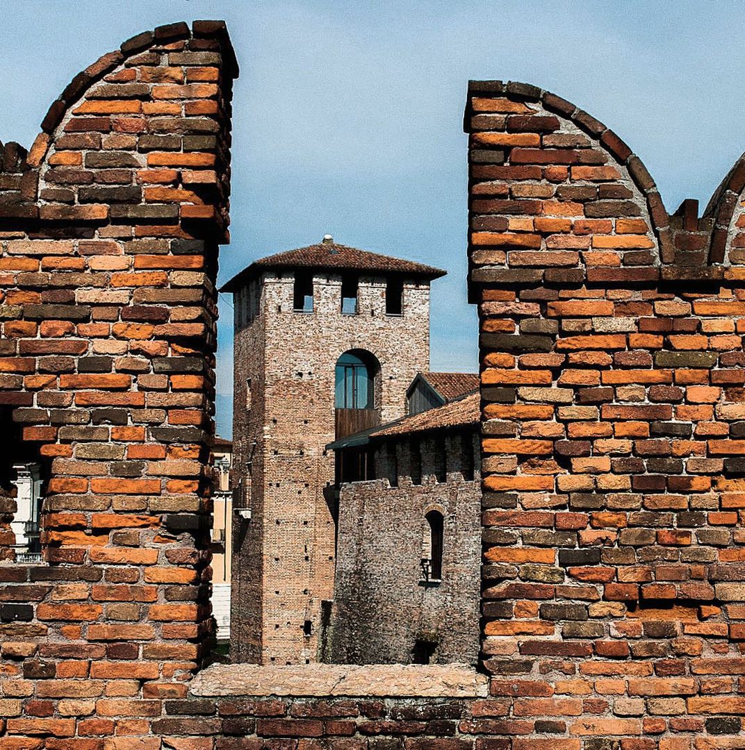 Low angle view of historic building seen through brick wall