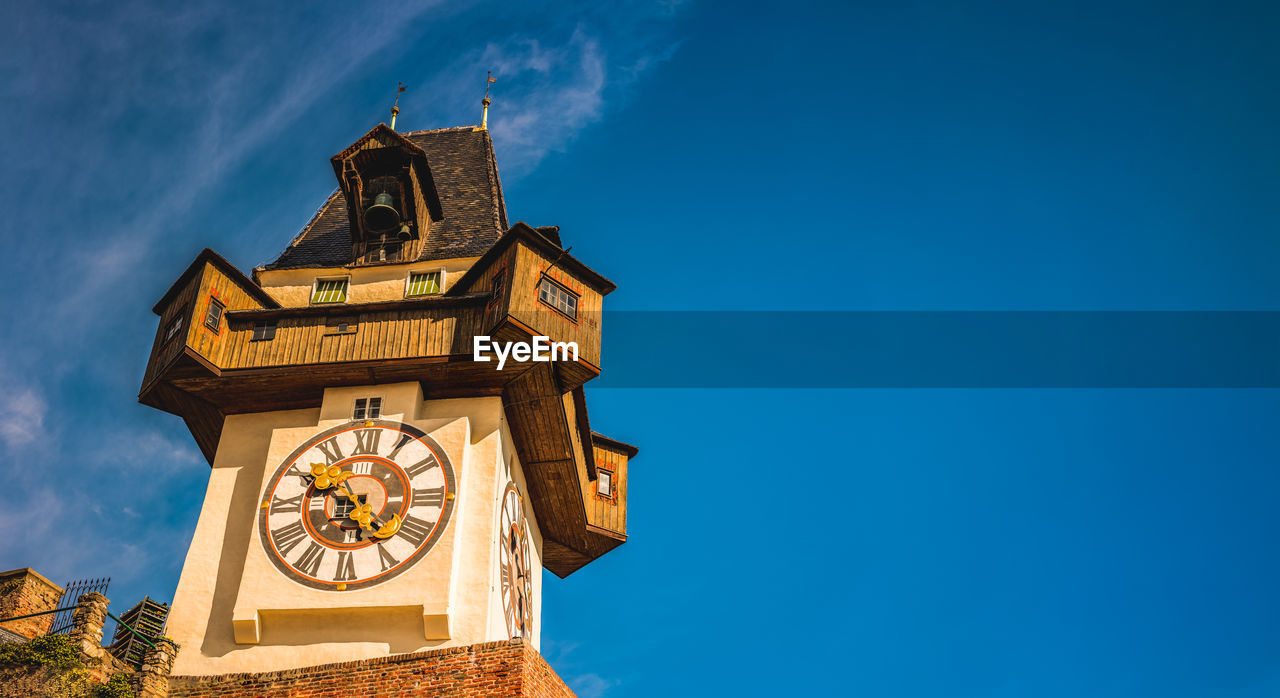  uhrturm landmark in graz cityscape view, styria region of austria. clocktower against blue sky