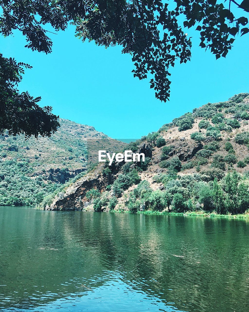 SCENIC VIEW OF RIVER BY MOUNTAIN AGAINST CLEAR BLUE SKY