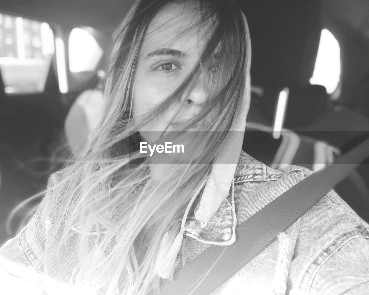 Portrait of young woman sitting in car