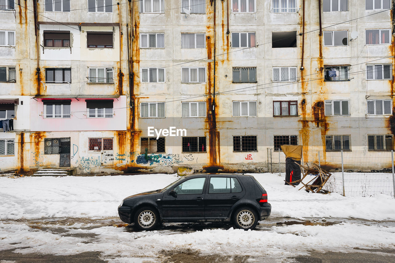 Cars on snow covered buildings in city