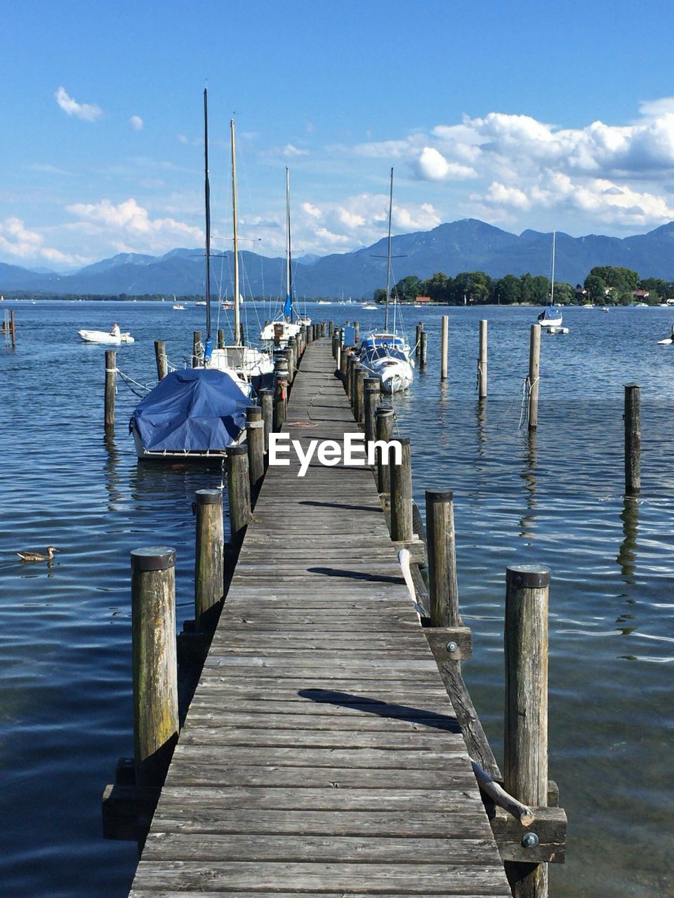 Wooden pier over lake against sky