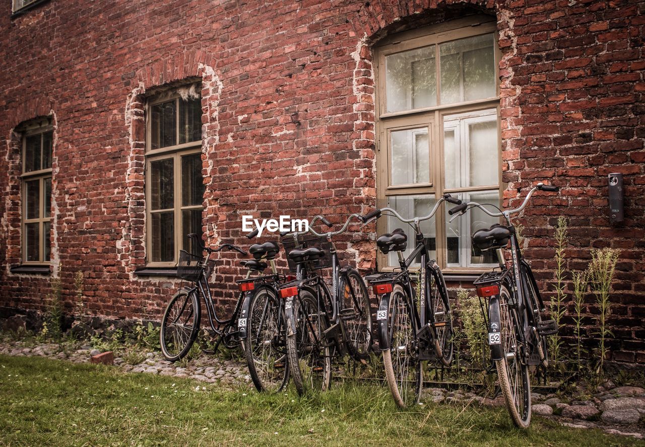 BICYCLE PARKED ON BRICK WALL