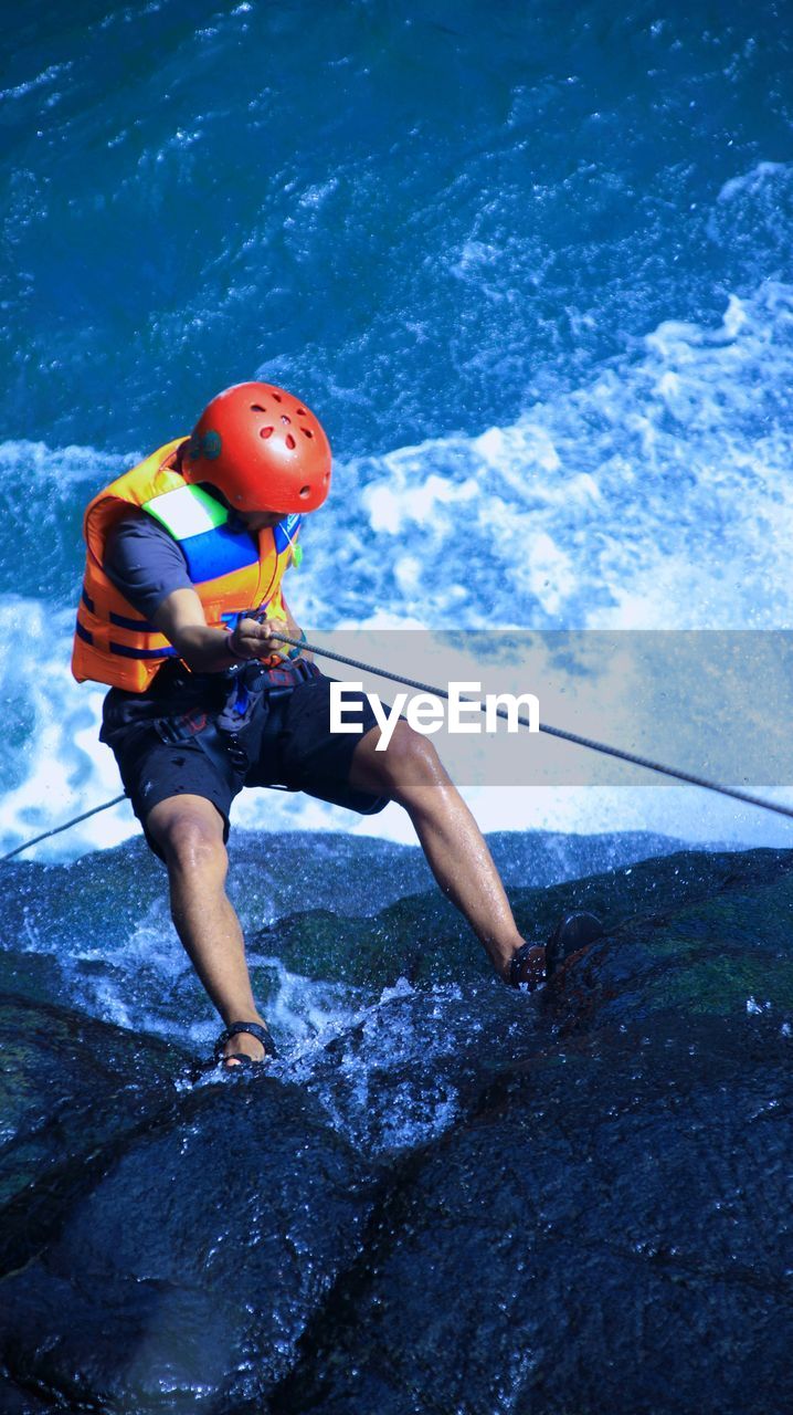 Rear view of man surfing in sea