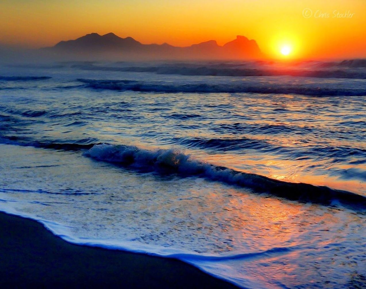 Scenic view of beach against orange sky