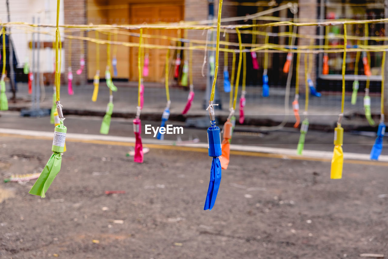 CLOSE-UP OF CLOTHESPINS HANGING ON CLOTHESLINE AGAINST BLURRED BACKGROUND