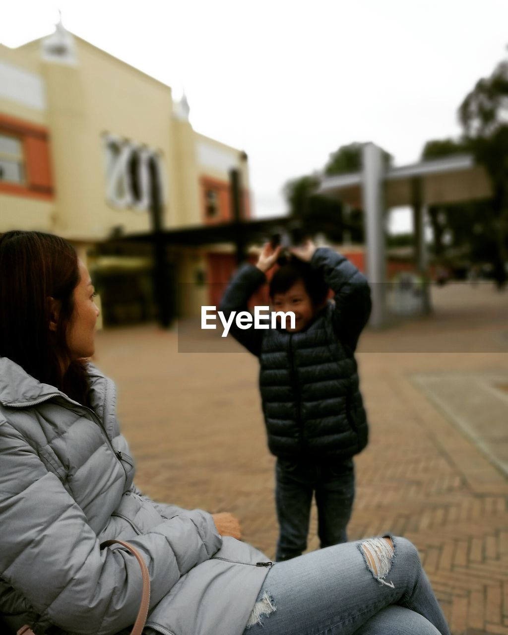 WOMAN STANDING IN FRONT OF BUILDING