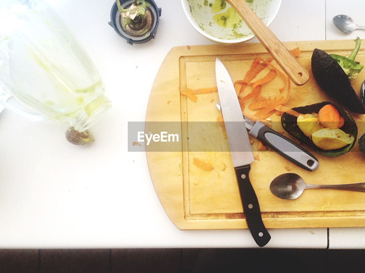 High angle view of kitchen utensils and vegetables on cutting board