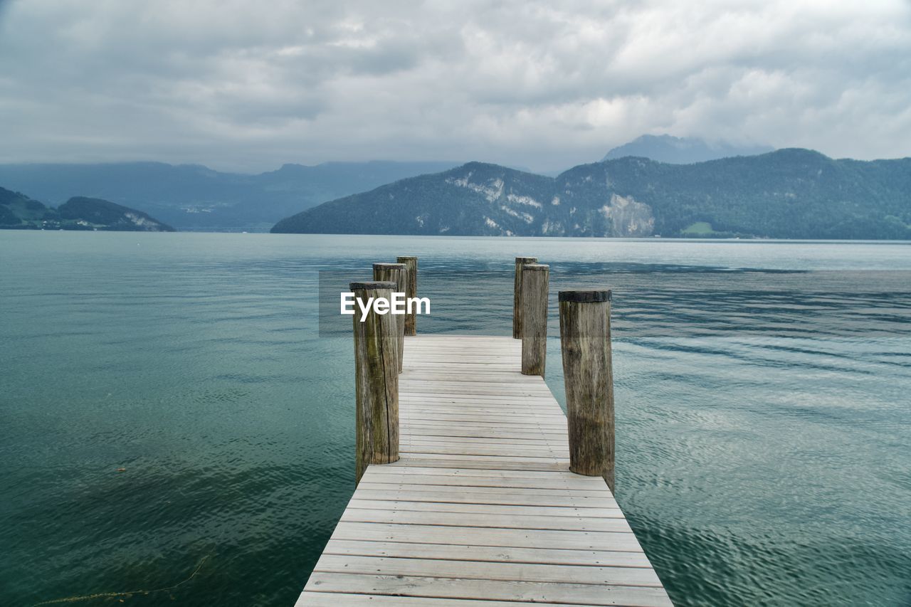 Wooden pier over sea against sky