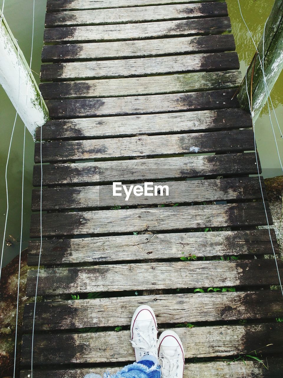 Low section of person walking on footbridge