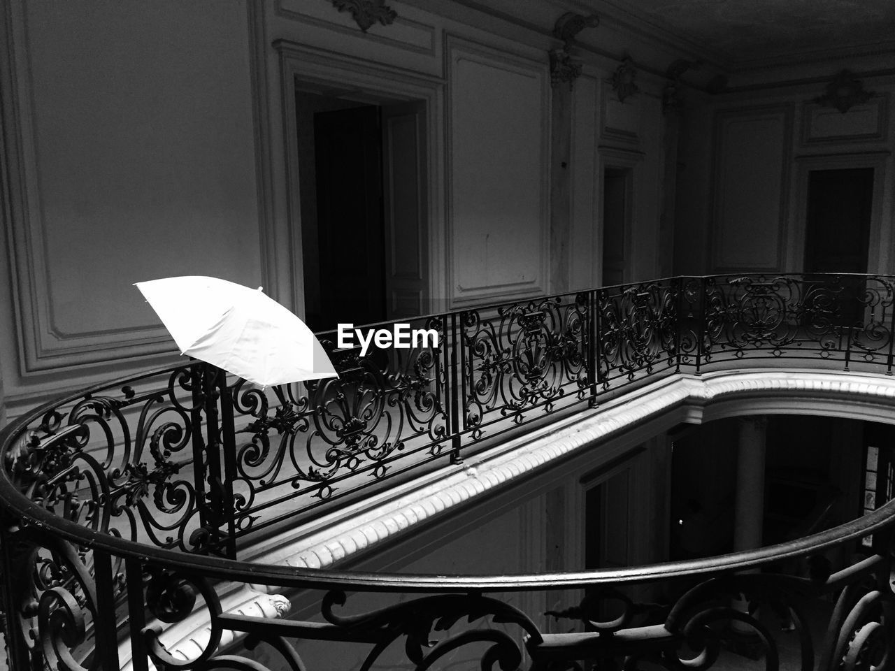 White umbrella on railing in building