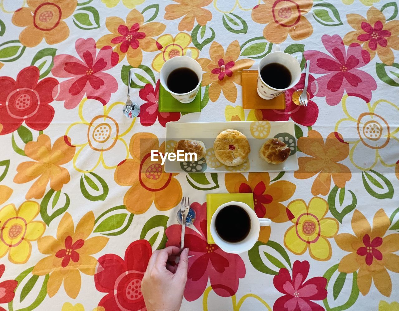 food and drink, coffee cup, cup, mug, pattern, flower, drink, coffee, tea, food, circle, floral pattern, art, tablecloth, one person, refreshment, indoors, high angle view, directly above, freshness, hand, table, petal, hot drink, saucer, tea cup, lifestyles, healthy eating, fruit, wallpaper, breakfast, flowering plant, multi colored, adult