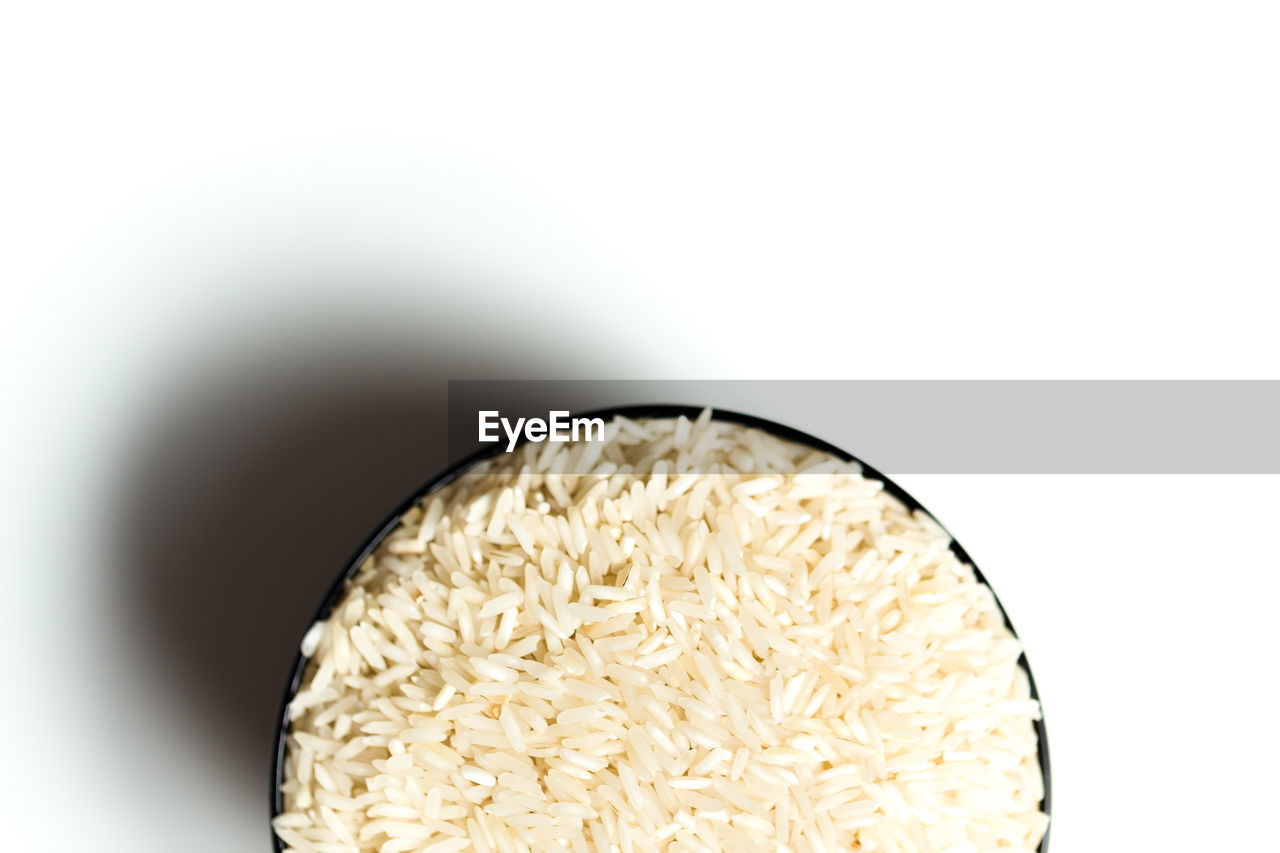 Directly above shot of rice in bowl against white background