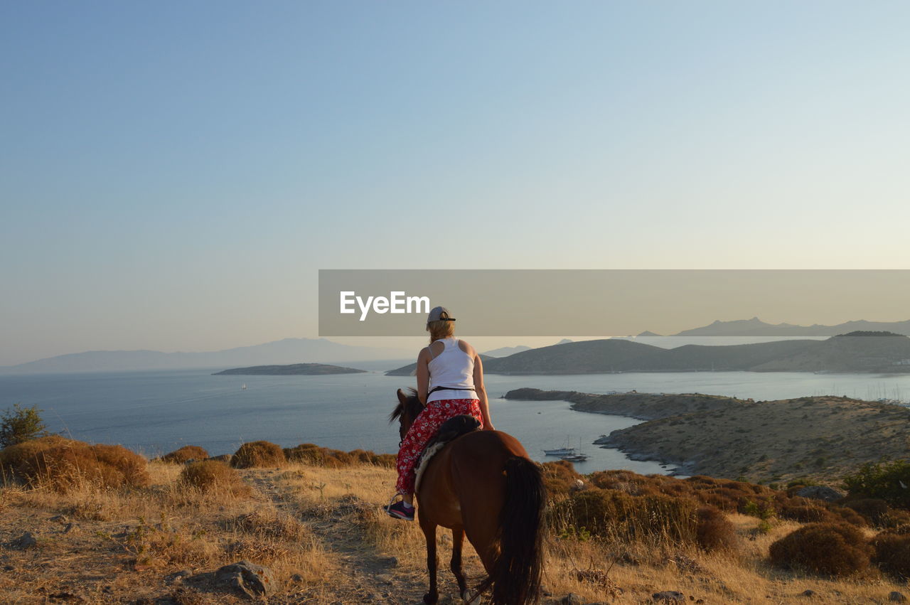 MAN RIDING HORSE ON A FIELD