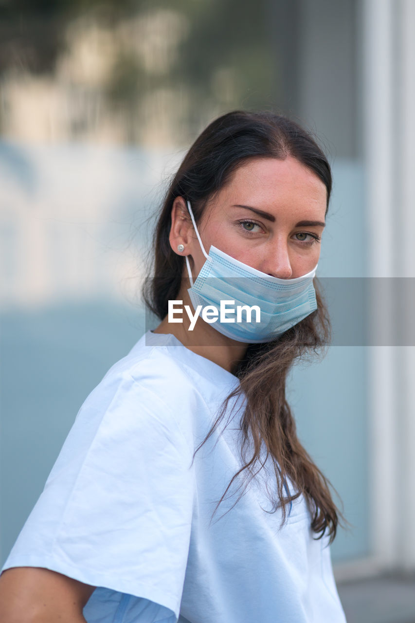 Medical worker posing covering her face with a protective mask