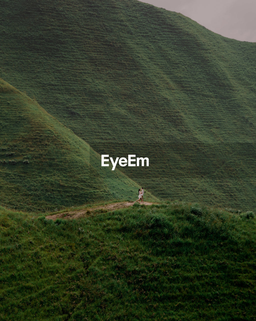 High angle view of couple on field by mountain against sky