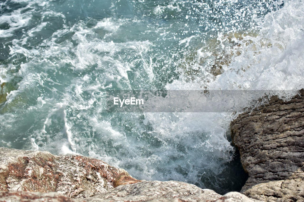 water, sea, motion, rock, wave, shore, beauty in nature, wind wave, coast, surfing, water sports, ocean, sports, rapid, beach, nature, splashing, day, breaking, land, scenics - nature, body of water, power in nature, high angle view, outdoors, rock formation, rough