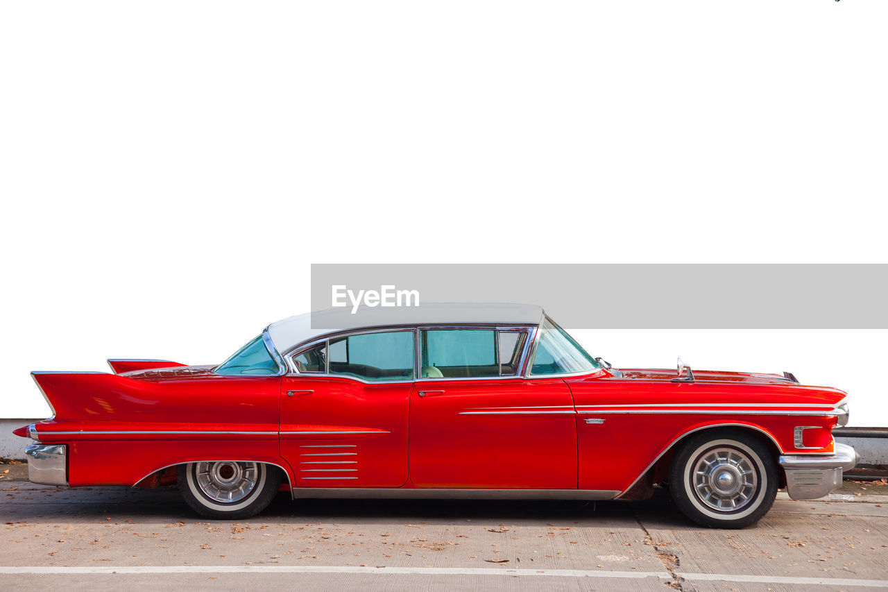 RED VINTAGE CAR AGAINST SKY