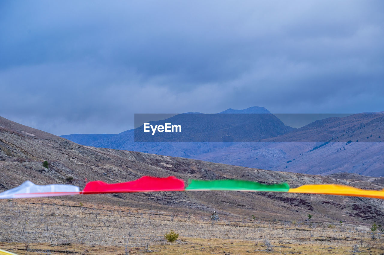 mountain, environment, sky, landscape, scenics - nature, mountain range, cloud, nature, beauty in nature, no people, non-urban scene, land, tranquility, travel destinations, tranquil scene, travel, day, outdoors, sea, flag, plateau, blue, multi colored, remote