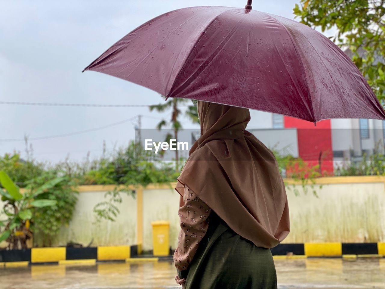 Rear view of hijab girl with umbrella on street