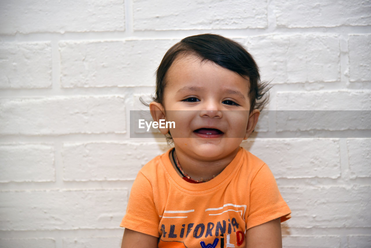 Portrait of cute boy against wall