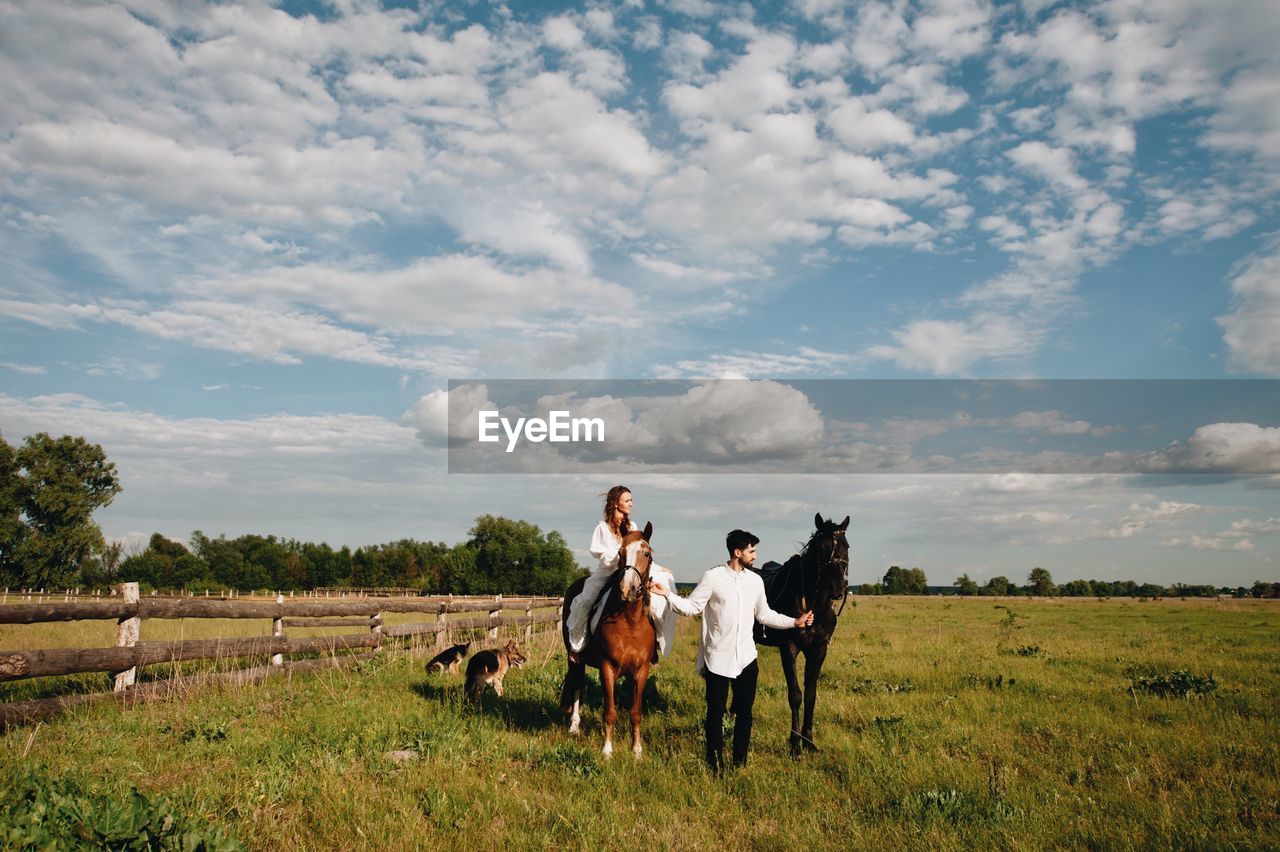 Couple riding horse on field