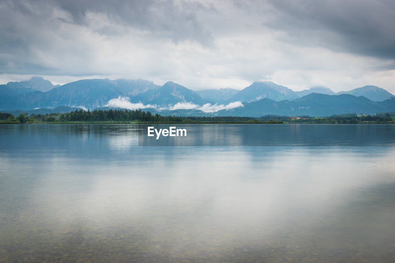 Scenic view of lake by mountains against sky