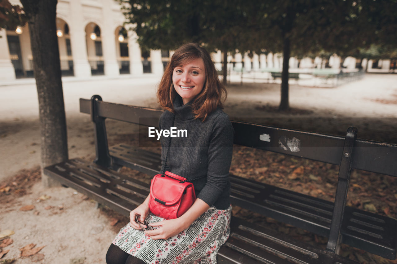 Portrait of young woman sitting on bench