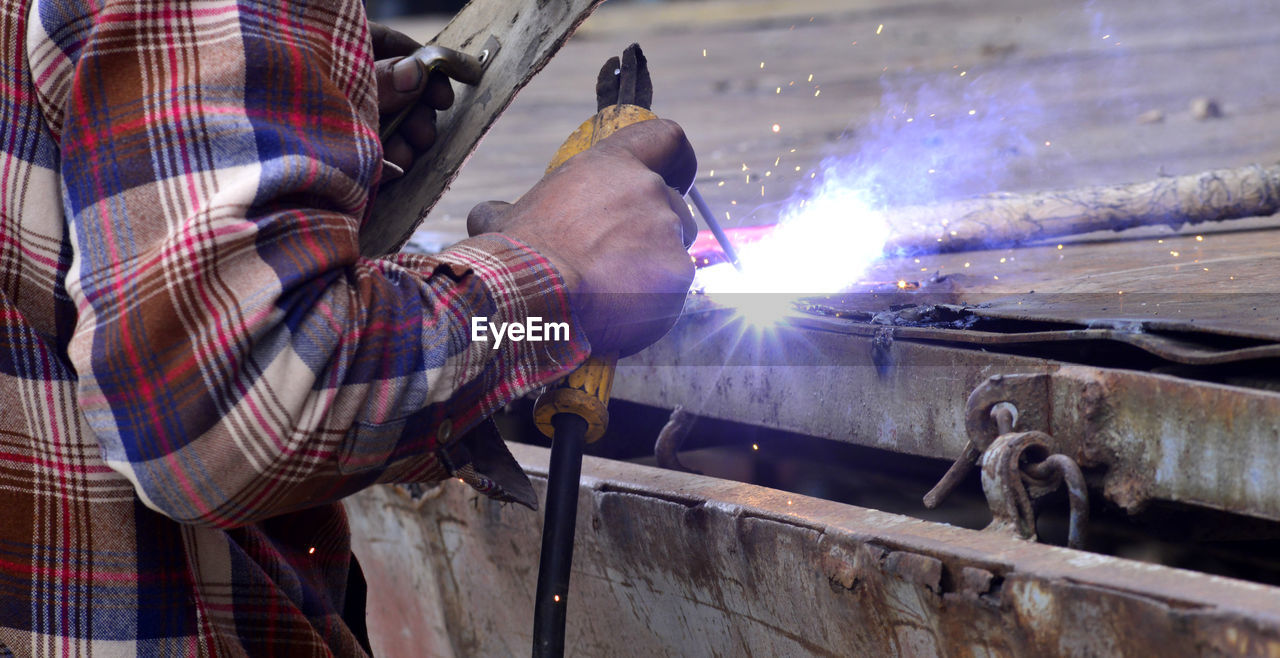 Midsection of man welding in workshop