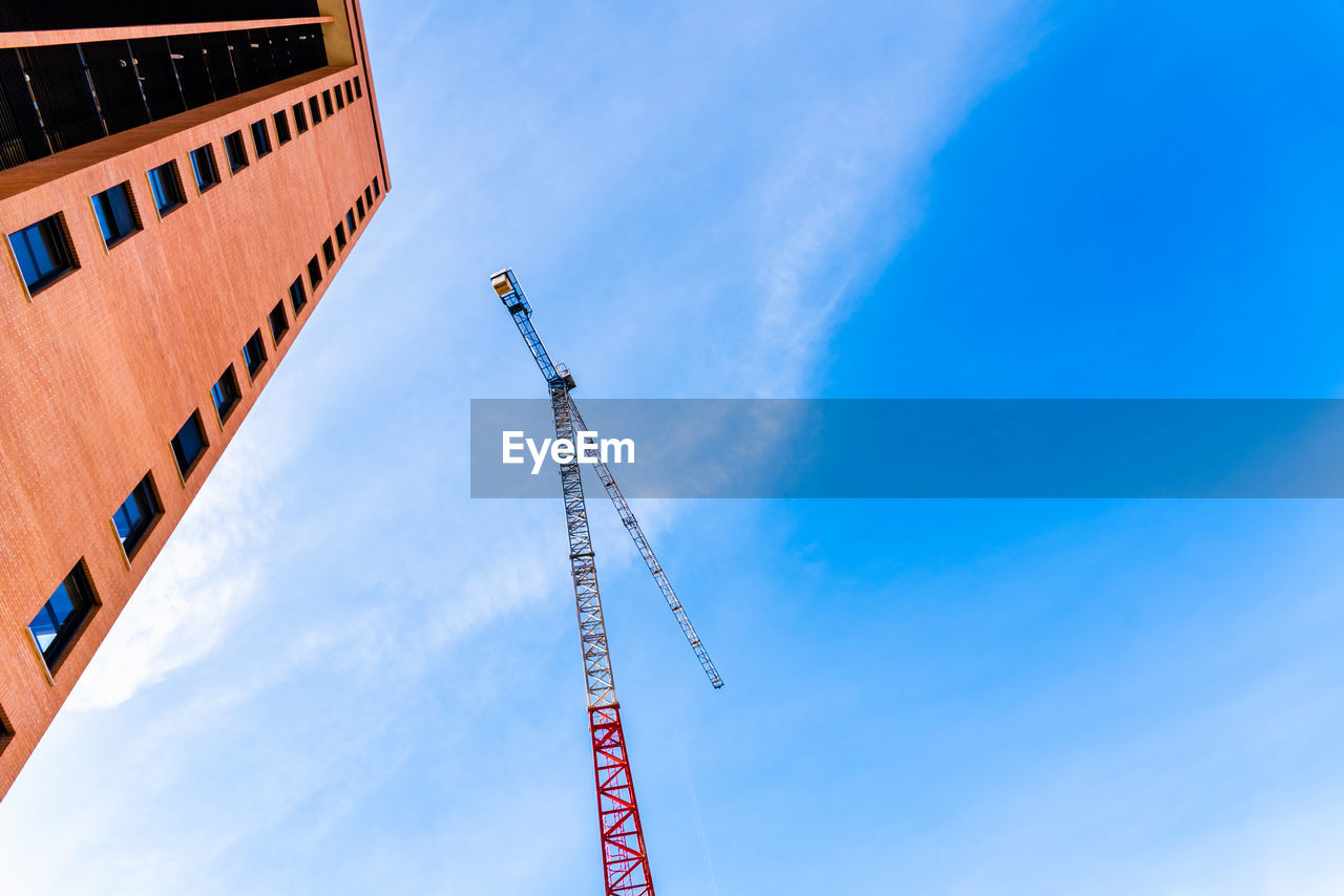 LOW ANGLE VIEW OF CRANE AGAINST BUILDING