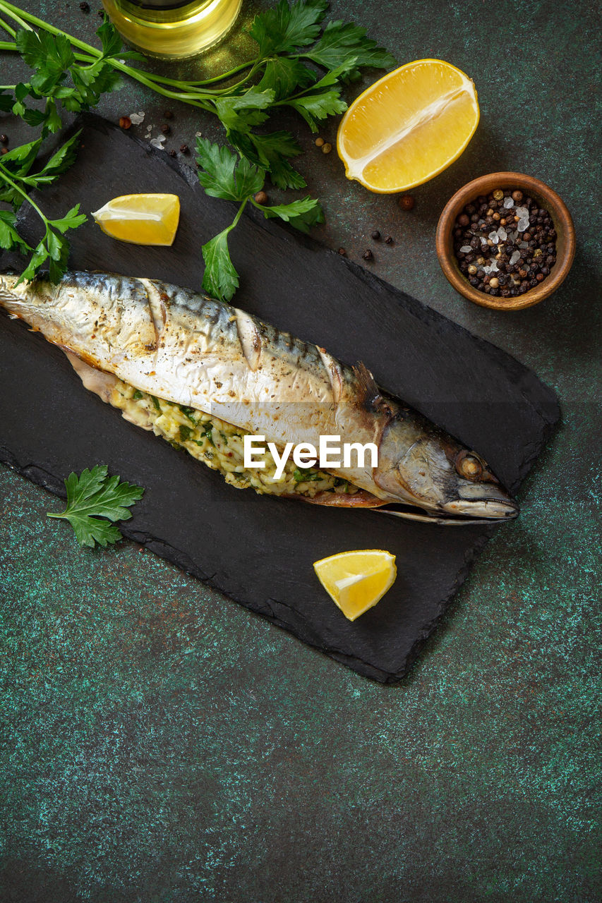 food and drink, food, healthy eating, herb, freshness, fish, wellbeing, citrus fruit, fruit, lemon, slice, no people, spice, ingredient, high angle view, plant, studio shot, produce, seafood, vegetable, wood, leaf, fast food, yellow, indoors, meal, parsley, plant part, dark