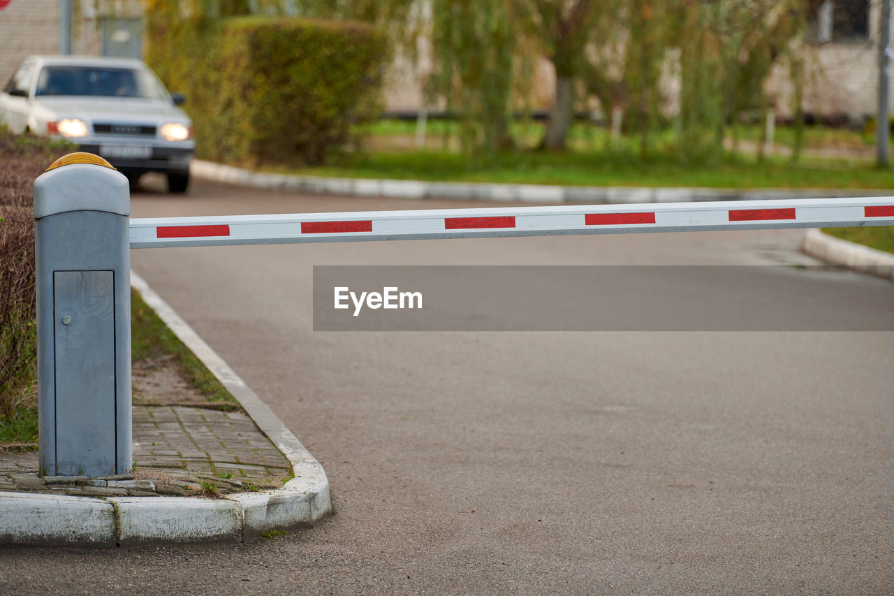 Parking gate, automatic car barrier system for car-park security. white red boom gate.