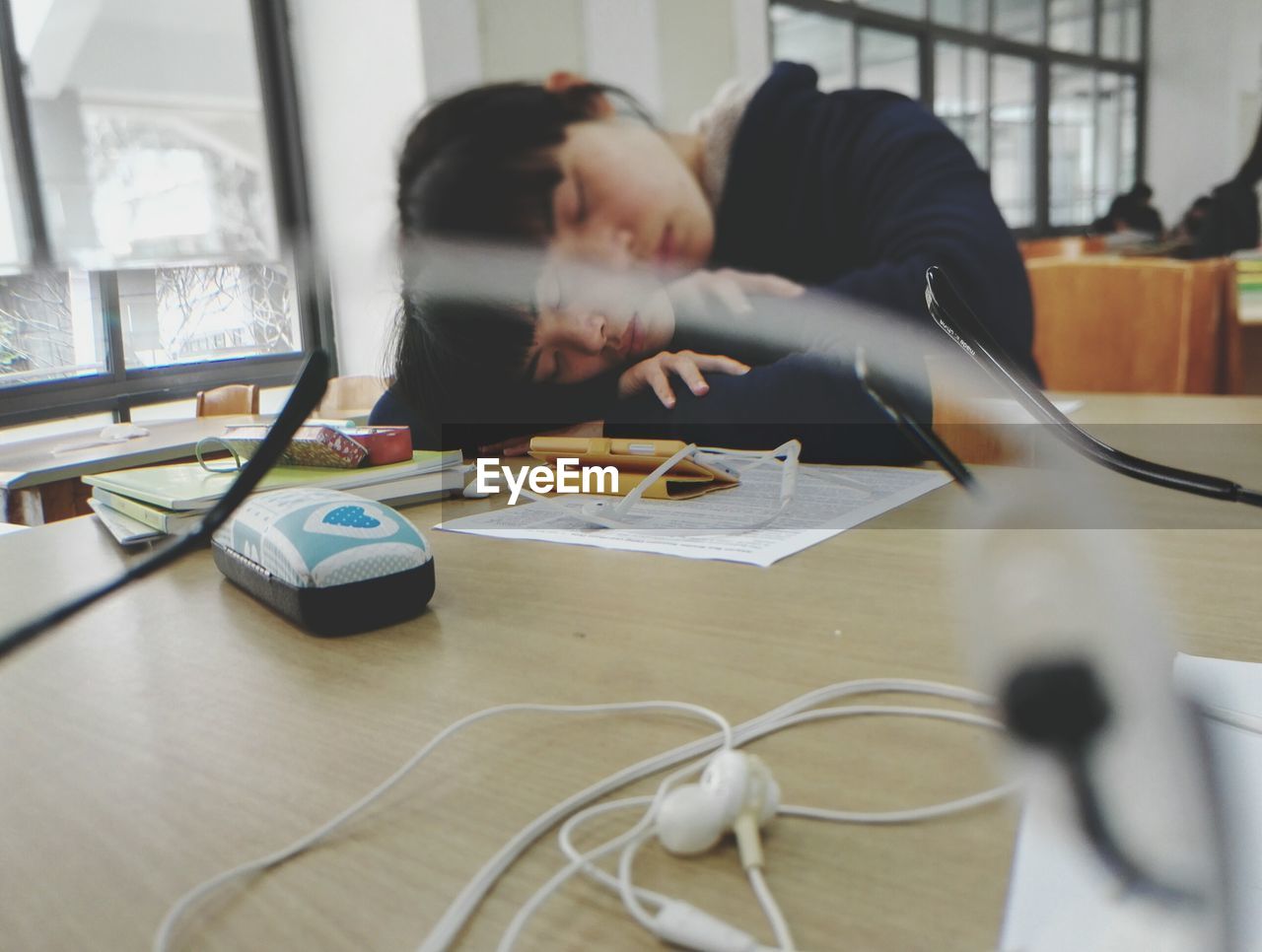 Young woman sleeping on library desk