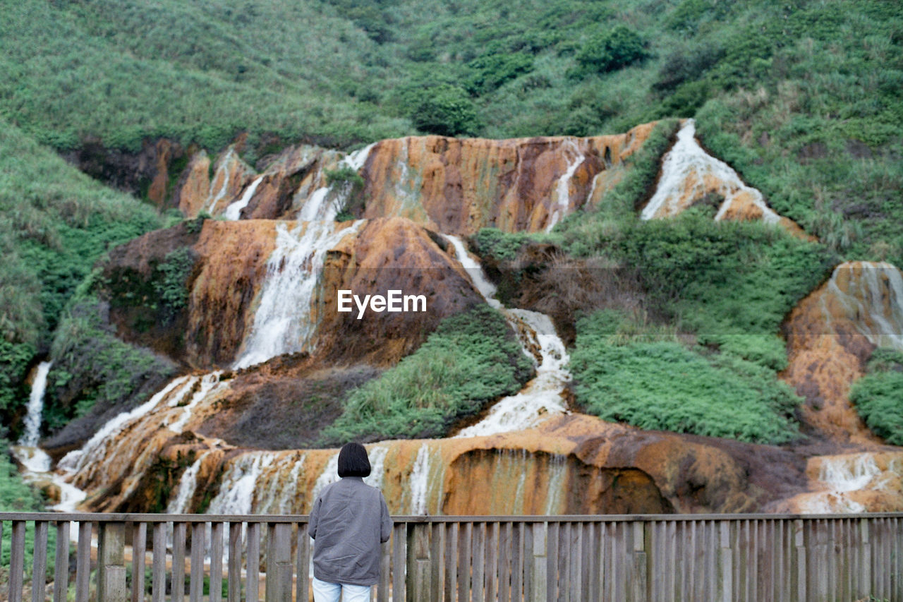 Woman in front of waterfalls on mountain