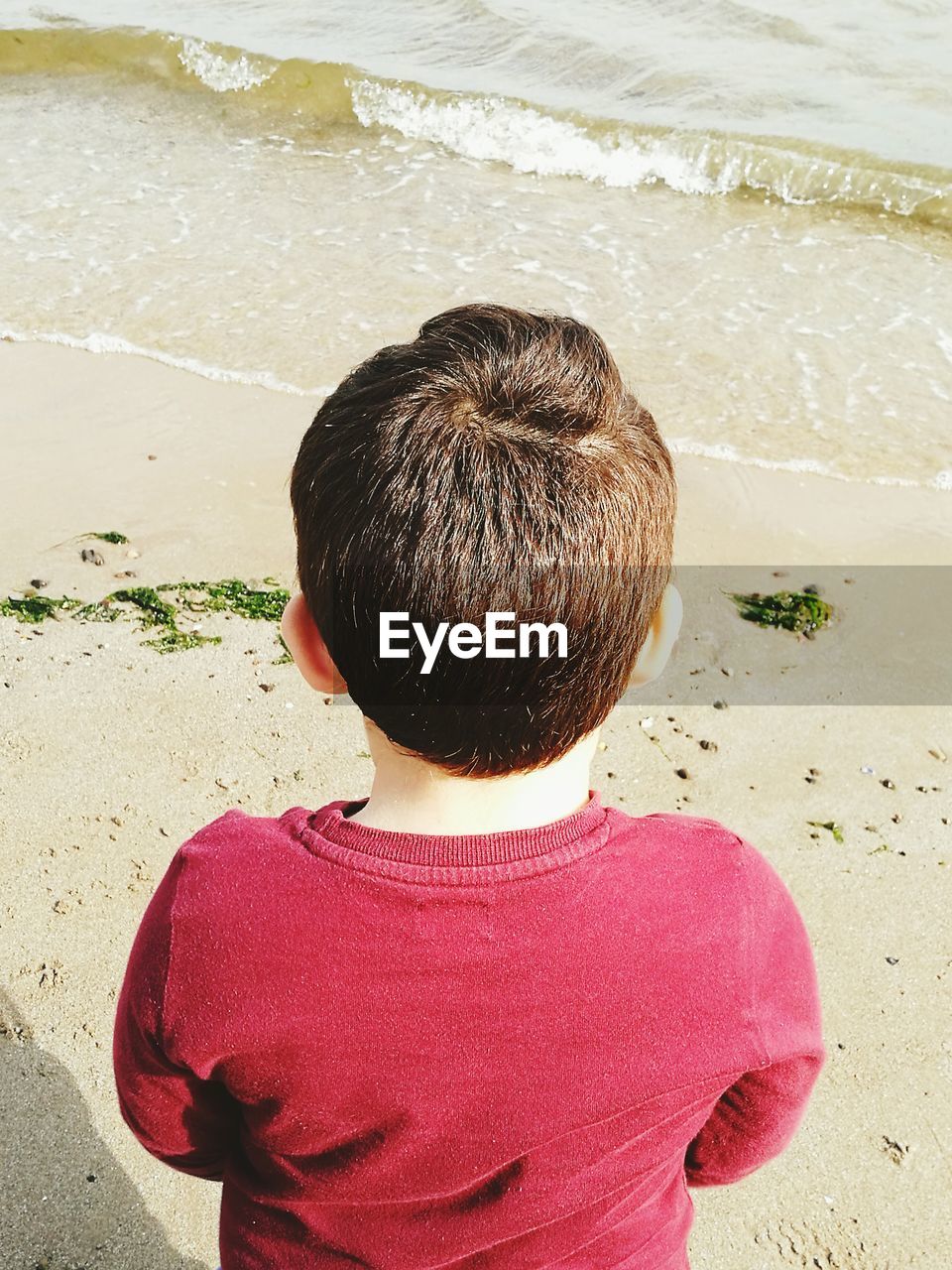 High angle view of boy standing on sand at beach