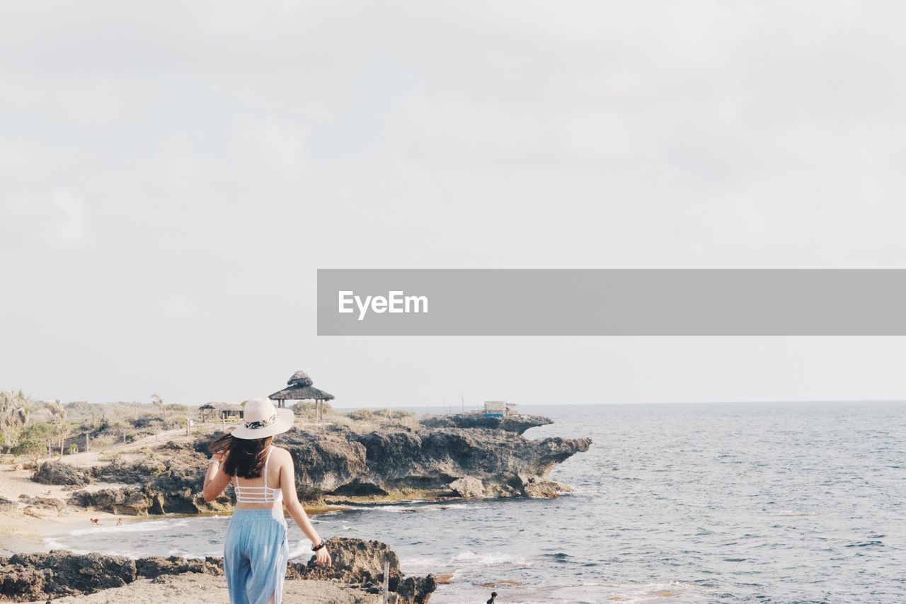 Rear view of woman looking at sea against sky