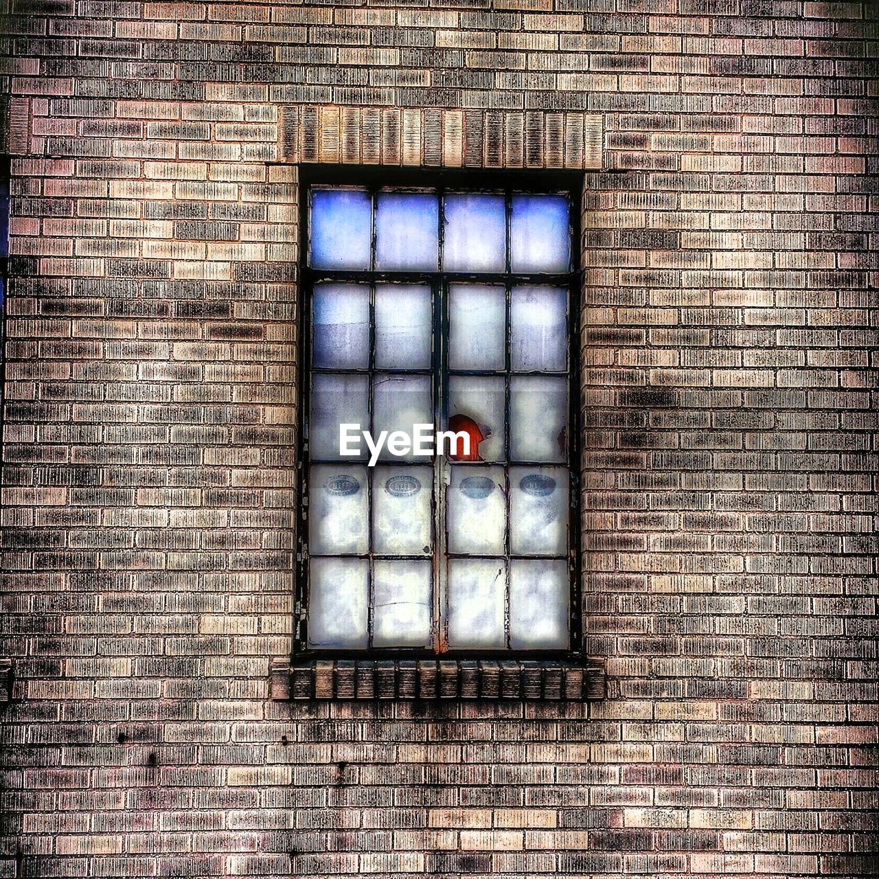 Close-up of glass window panes on brick wall