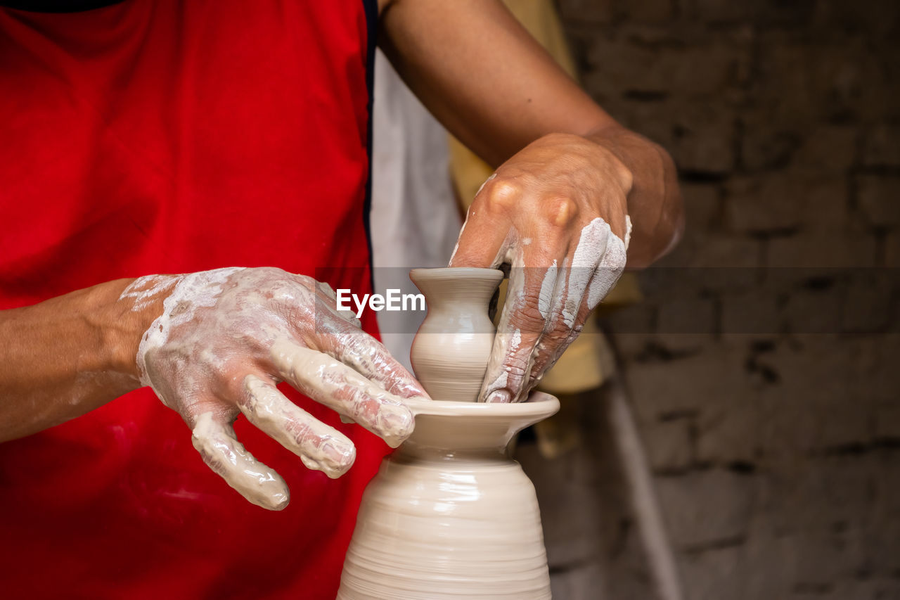 Midsection of man working in mud