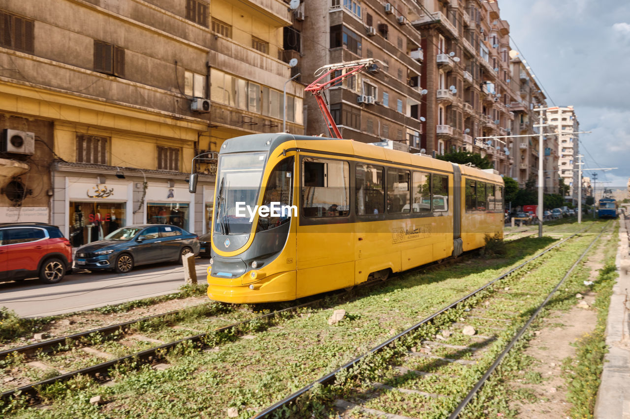 Modern yellow tram driving on a tram line. alexandria, egypt - march 2023