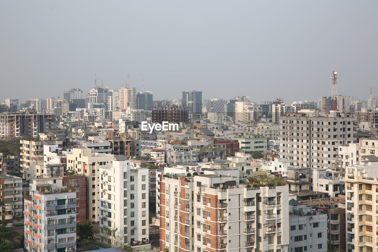 Aerial view of buildings in city against clear sky