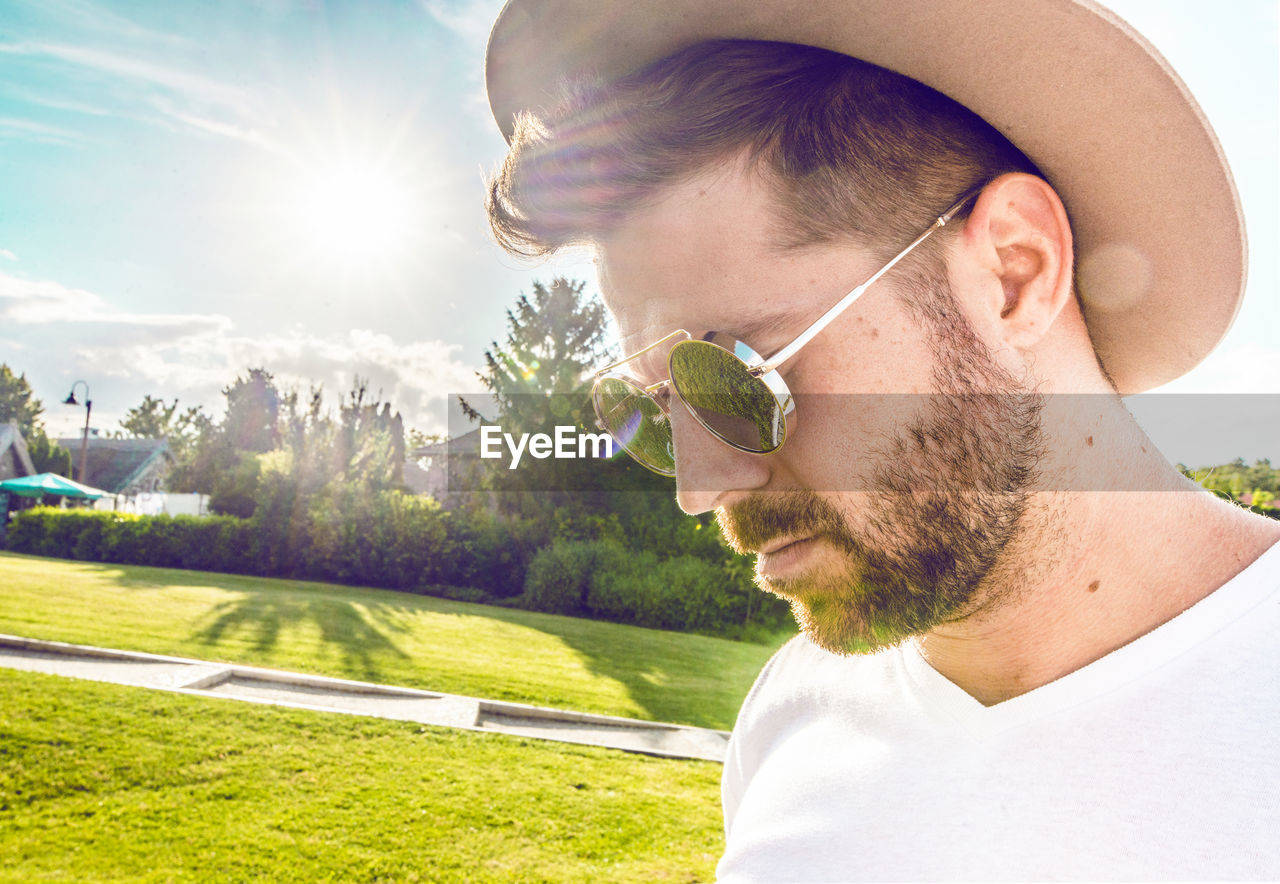 Close-up of man wearing sunglasses and hat at park