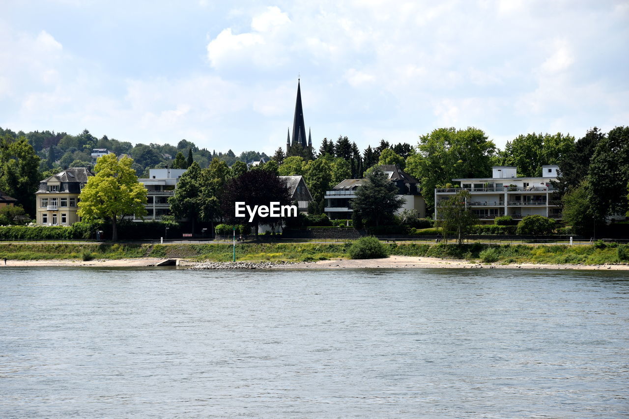 RIVER BY BUILDINGS AGAINST SKY